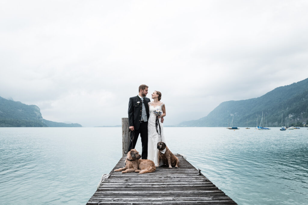 Brautpaar mit Hunden am See